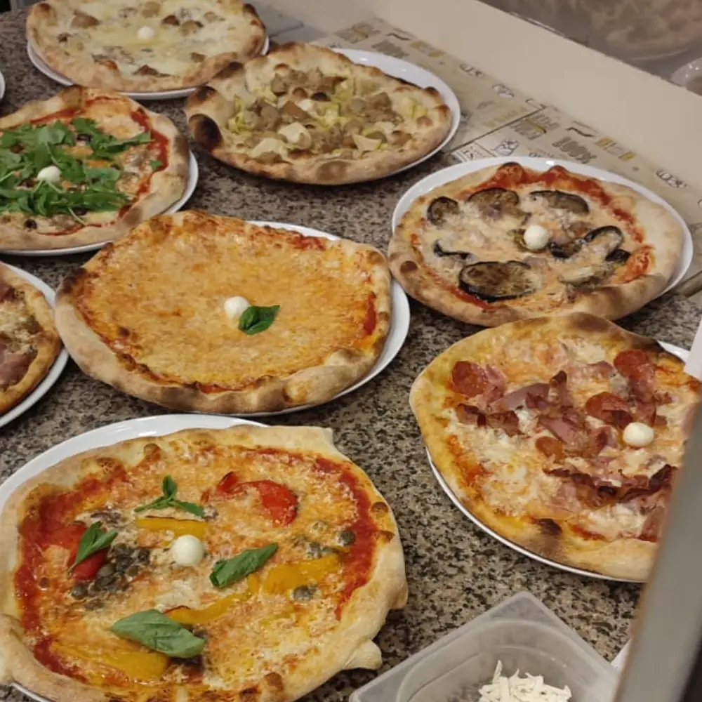 Pizze appena sfornate sul banco, pronte per l'asporto