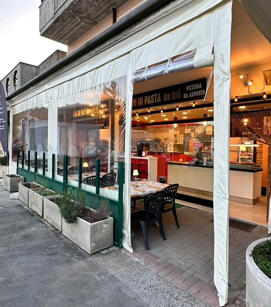 L'ingresso con la veranda e l'insegna nera e oro Mani in Pasta da Giò, pizzeria da asporto