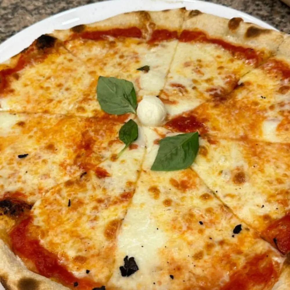 Pizza con pomodoro, mozzarella e basilico tagliata a spicchi