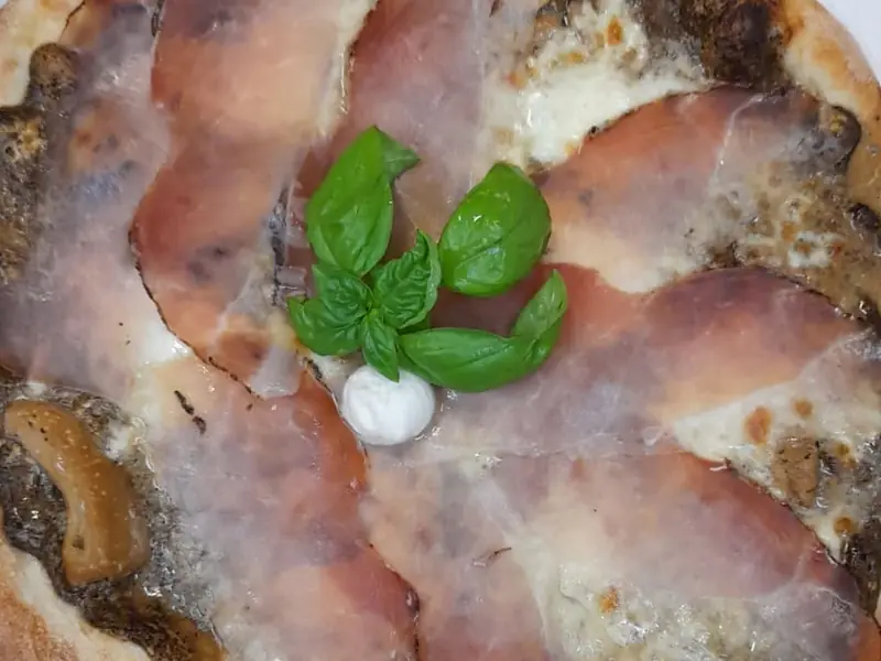 Pizza con speck, porcini e basilico